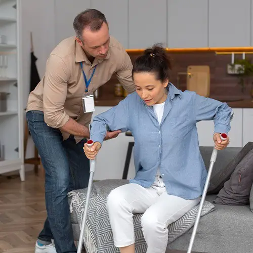 NYHC's home health aide assisting a handicapped woman to stand, showing our dedication to providing supportive home health services
