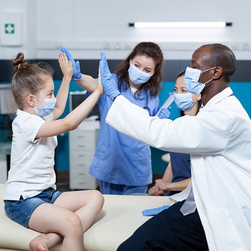 NYHC's Pediatric Nurse Service: A heartwarming scene with a doctor and two pediatric nurses giving a high-five to a child, showing our compassionate approach to pediatric care.